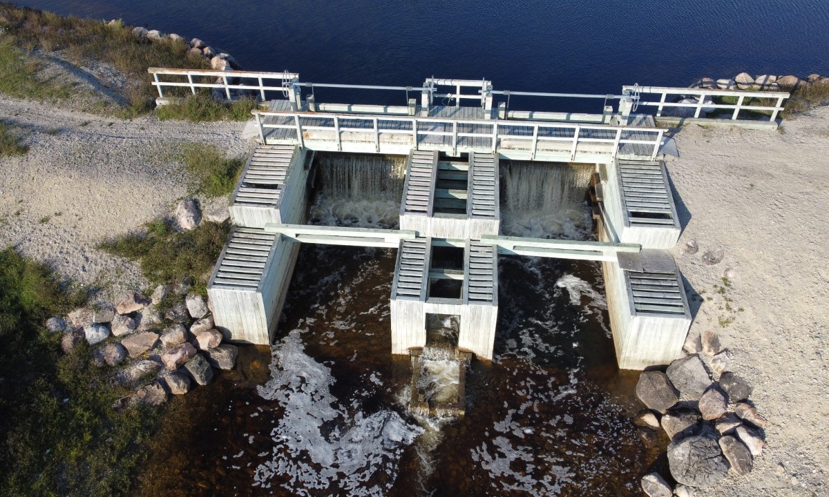 Vue aérienne d’un barrage retenant un plan d’eau entouré de forêt et d’un chemin d’accès  à Acton Vale