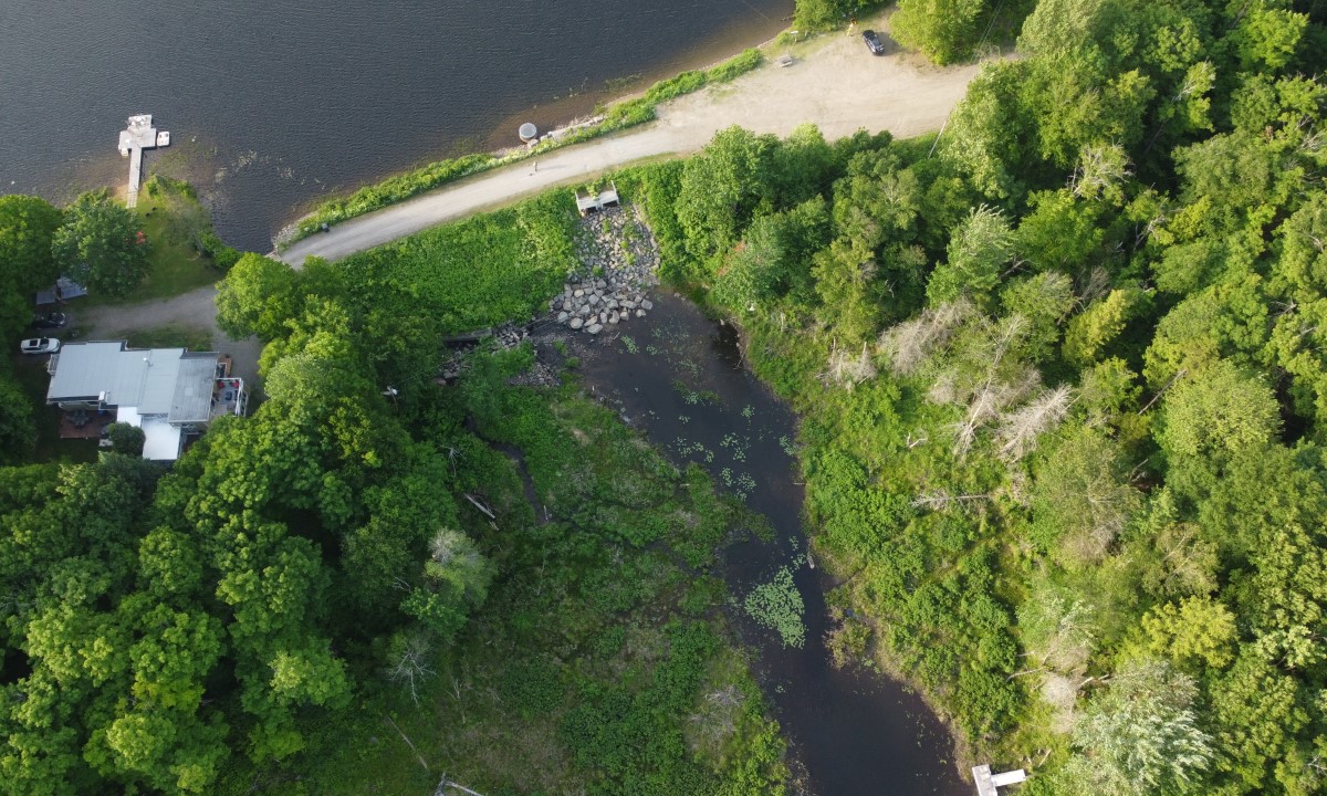 Barrage à faible hauteur avec écoulement visible sur un seuil rocheux dans un environnement naturel  à Chibougamau