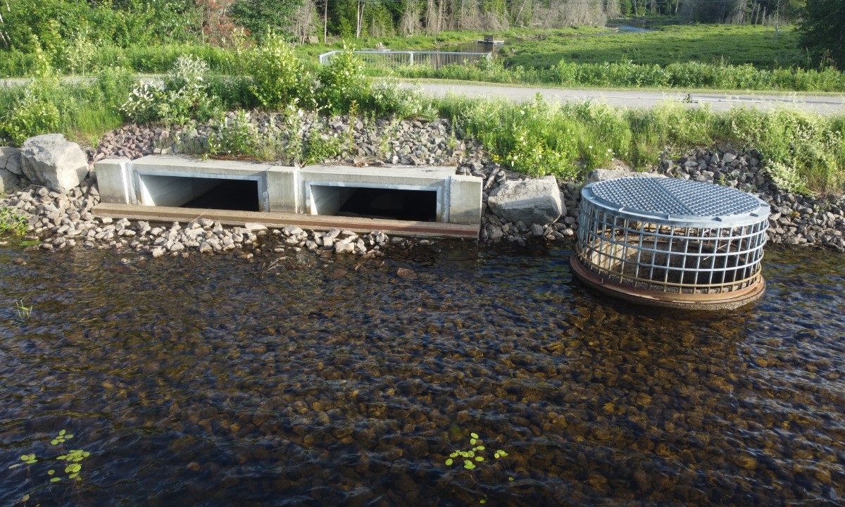 Ouvrage de contrôle de l’eau avec structures en béton et enrochement visible dans un cours d’eau  à Saint-Raymond